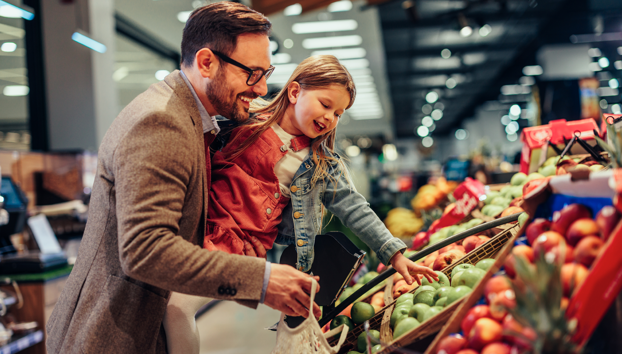 Father and daughter shopping for fresh food at grocery store